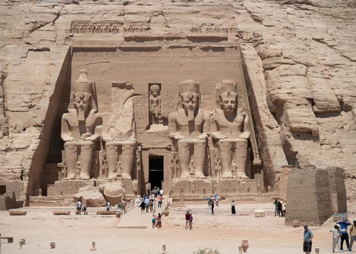 Viaje a Luxor y Abu Simbel – Vista exterior del Templo de Abu Simbel con sus estatuas monumentales de Ramsés II iluminadas por el sol.
