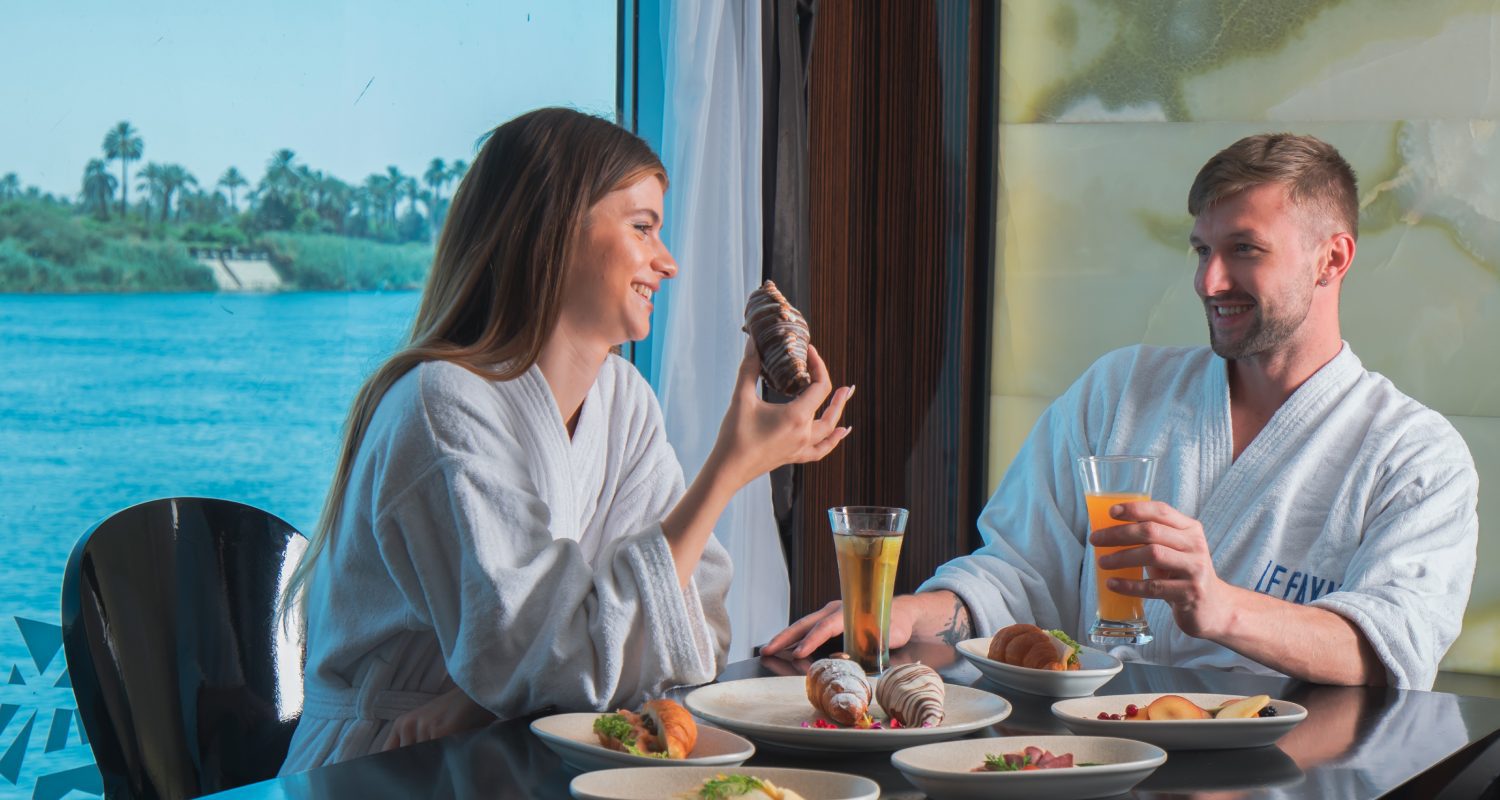 Crucero de Lujo por el Nilo Le Fayan 4 y 5 Días desayuno en el restaurante a bordo con pasajeros disfrutando de la comida.