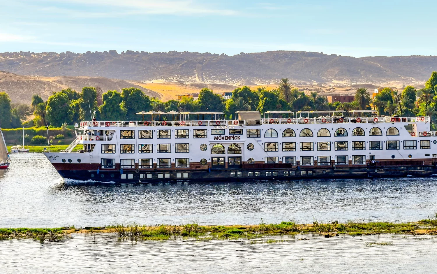 Crucero por el Nilo del lujo Mövenpick MS Sun Ray navegando por el Nilo con vistas panorámicas.