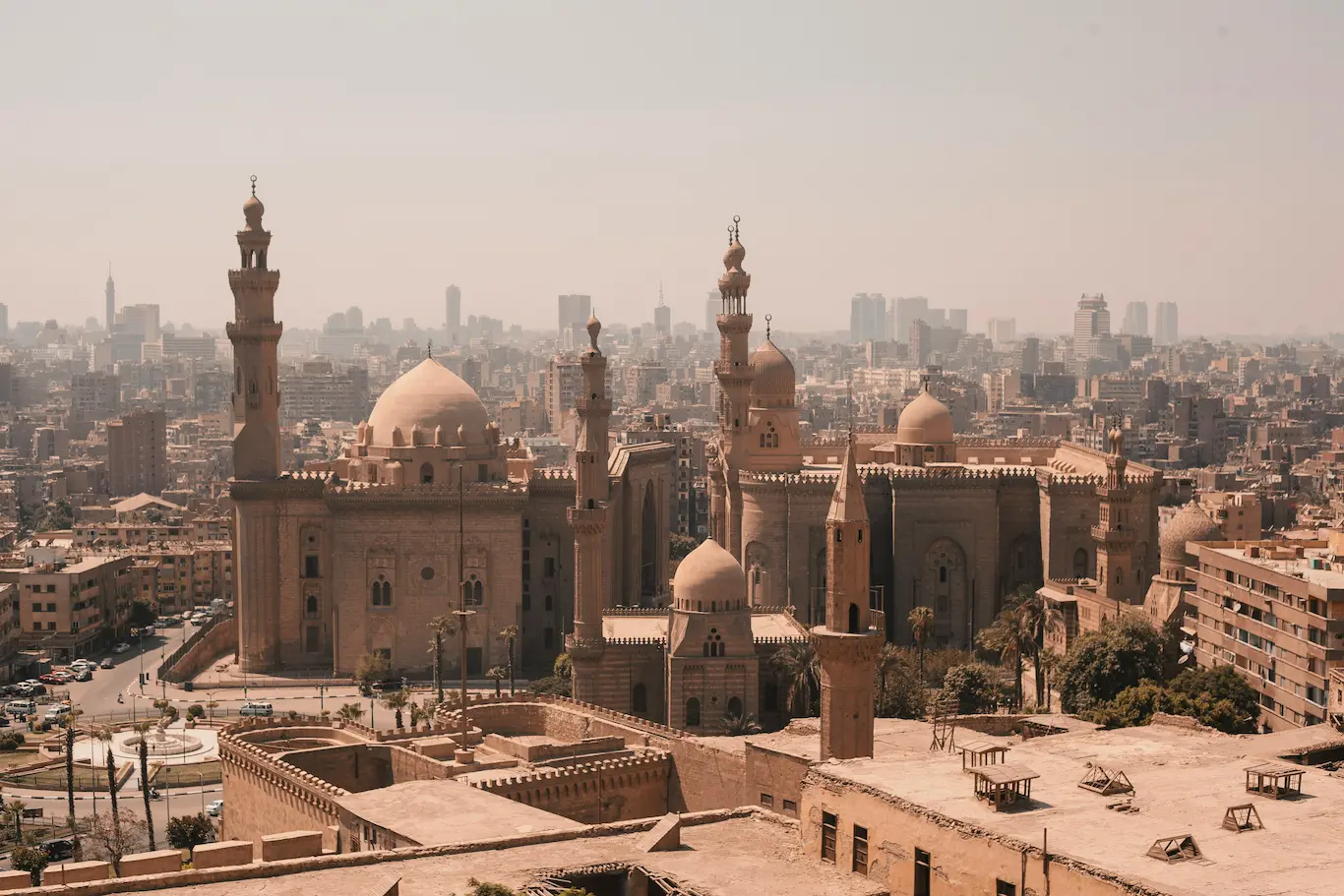 Viajeros frente a monumentos históricos en Egipto incluyendo la Mezquita del Sultán Hassan en Cairo, mostrando la mezcla entre cultura islámica y civilización faraónica