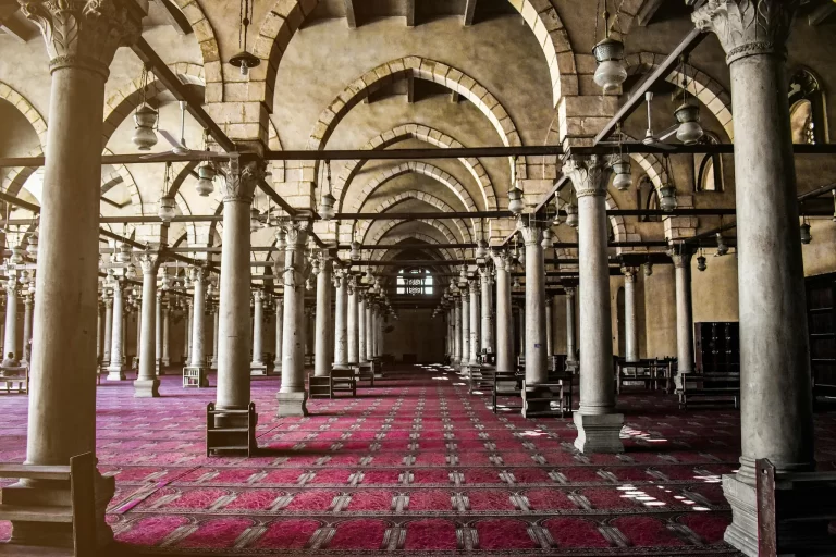 Vista colorida del patio de La Mezquita de Amr Ibn Alas en El Cairo con columnas históricas y arquitectura islámica antigua